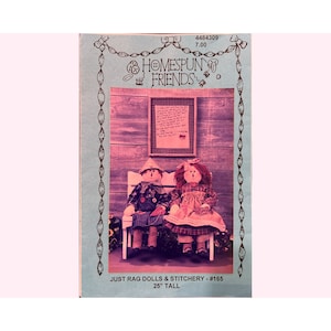 May include: A vintage sewing pattern for two rag dolls sitting on a bench. The pattern is titled "Homespun Friends" and is for "Just Rag Dolls & Stitchery - #165, 25" tall".
