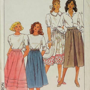 May include: A sewing pattern illustration featuring four outfits. Two outfits include white short-sleeved tops with pink or blue skirts. One outfit shows a white collared top with a floral skirt. One outfit shows a white collared shirt with a brown skirt.