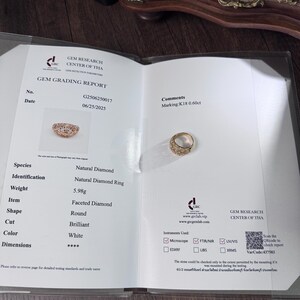 May include: A Gem Grading Report displays a natural diamond ring. The ring is round, faceted, and brilliant cut, with a white color. The report indicates a weight of 5.98 grams and a marking of K18 0.60ct.