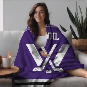 May include: Purple fleece blanket with a white hockey stick design and the text "WHL".