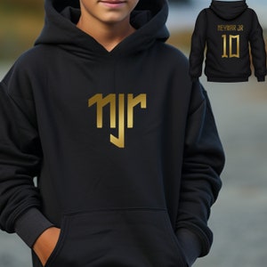 May include: Black hoodie with a gold "NJR" logo on the front. The back of the hoodie has "Neymar Jr" and the number "10" in gold.