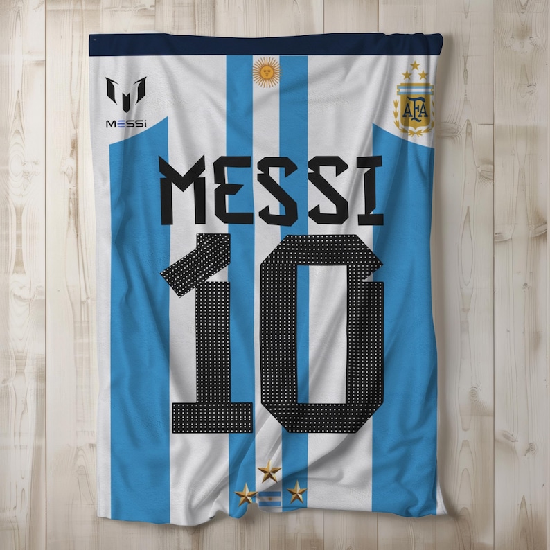 May include: A white and light blue soccer jersey with the name "MESSI" and the number "10" printed on the front. The jersey has the Argentinian national team logo on the right side and the Adidas logo on the left side.