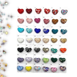 May include: Assortment of 42 heart-shaped rhinestone embellishments in various colors, including red, blue, green, gold, and silver. Each heart is approximately 1 inch in diameter.