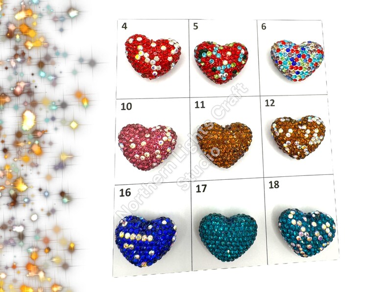 May include: Assortment of 10 heart-shaped rhinestone embellishments in various colors, including red, blue, green, brown, and pink. Each heart is approximately 1 inch in size.
