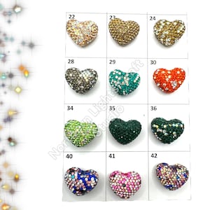 May include: Assortment of 10 heart-shaped rhinestone embellishments in various colors, including gold, silver, green, blue, red, and pink. Each heart is numbered 22 through 42.