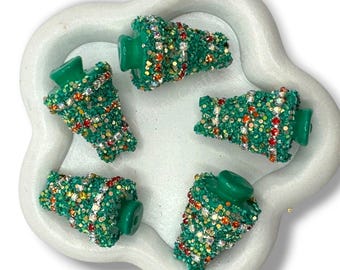 May include: Five green, cone-shaped charms with a textured surface covered in small, sparkling rhinestones in shades of red, gold, and clear. Each charm features a smooth, solid green plastic top section and a flat base.