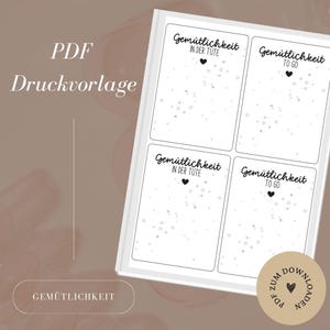 May include: Printable PDF sheet with four labels that say "Gemütlichkeit in der Tute" and "Gemütlichkeit to go". Each label has a small heart and a white background with grey dots.