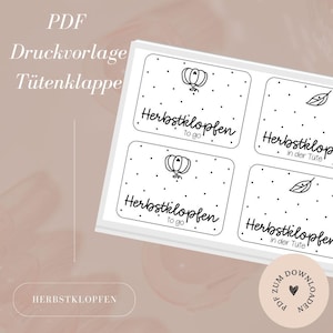 Puede incluir: Una hoja de etiquetas rectangulares blancas con texto e ilustraciones en negro. Las etiquetas presentan el texto "Herbstklopfen to go" y "Herbstklopfen in der Tüte", junto con gráficos de calabaza y hojas. También se ven las palabras "PDF Druckvorlage Tütenklappe".