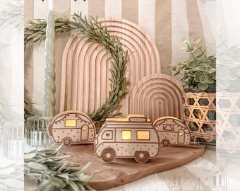 Può includere: Tre portacandele in legno a forma di camper con finitura marrone chiaro. I portacandele sono decorati con pois bianchi e cuori. I portacandele sono posizionati su una superficie in legno con uno sfondo in legno.