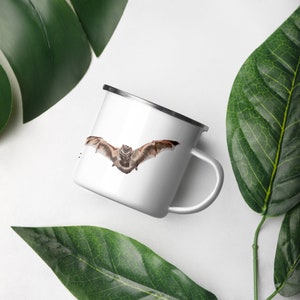 May include: White enamel mug with a brown and gray bat illustration. The bat is flying with its wings spread out.