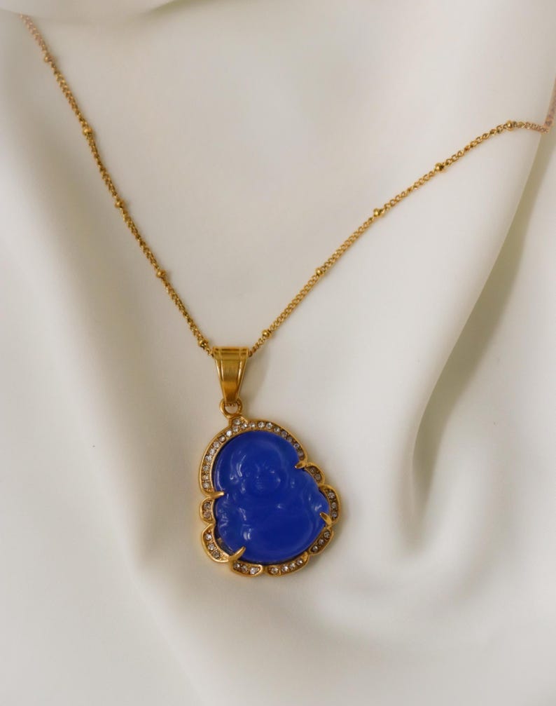 a gold necklace with a blue pendant and a gold chain.