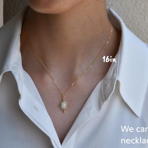 a woman wearing a white shirt and a gold necklace