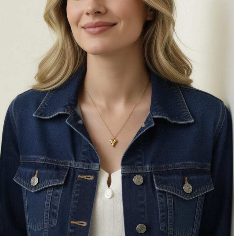 A woman wearing a blue denim jacket and a white top, smiling at the camera.