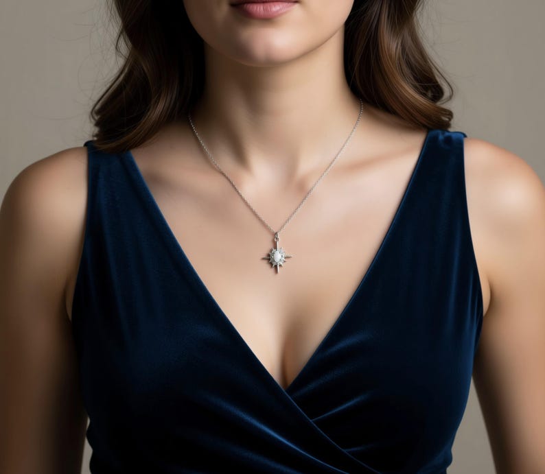 A woman wearing a blue velvet dress and a necklace with a pendant is shown in the image.