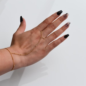 a woman's hand with black and gold nail polish