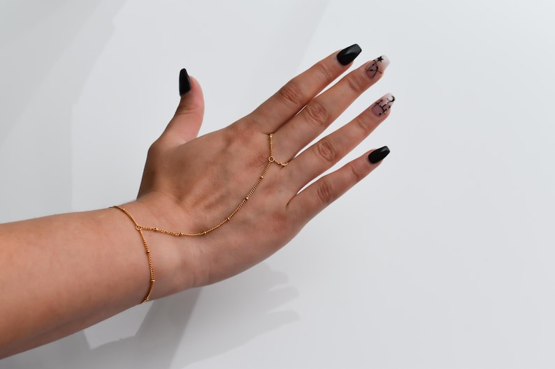 a woman's hand with black and gold nail polish