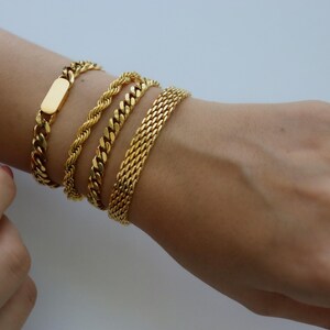 A close-up view of a person's wrist adorned with multiple gold bracelets.
