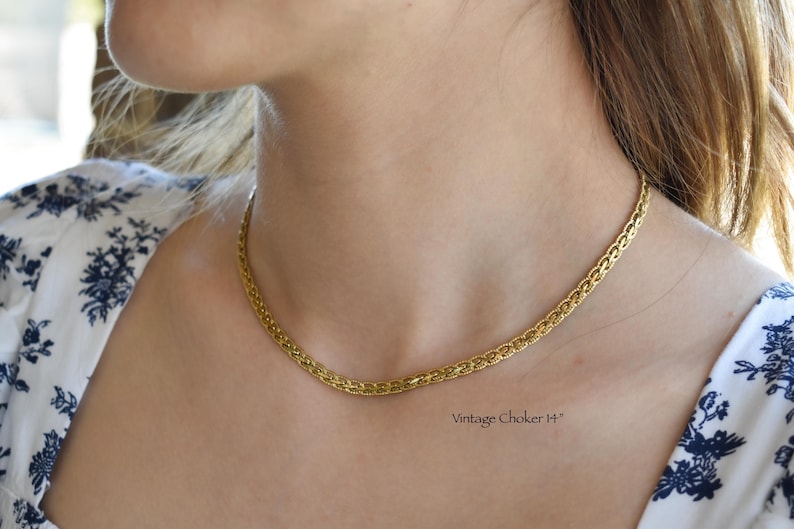 A close-up of a woman's neck and chest wearing a gold chain necklace.
