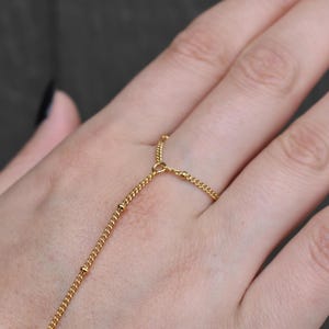 a woman's hand with a gold chain bracelet on it