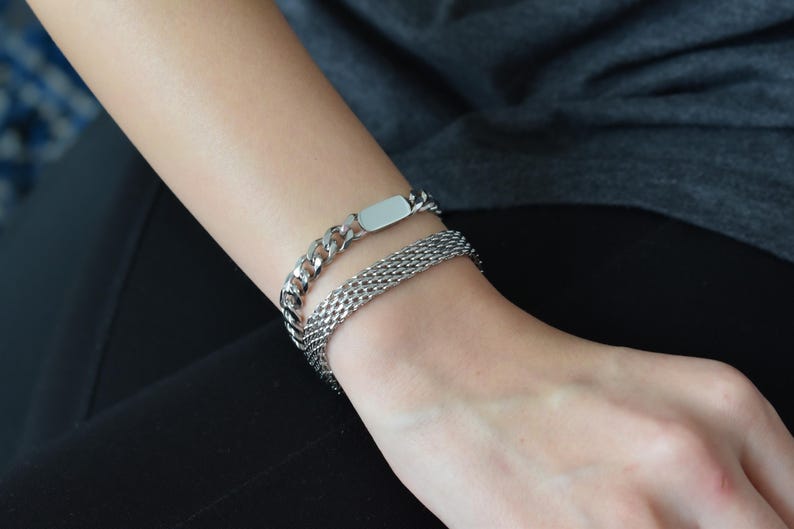 A close-up view of a person's wrist wearing a silver bracelet with a chain-link design.