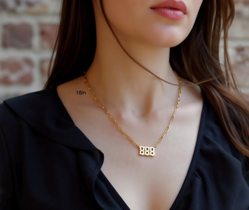 A close-up of a woman wearing a gold necklace with a small pendant.