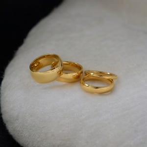 A group of gold rings is displayed on a white surface.
