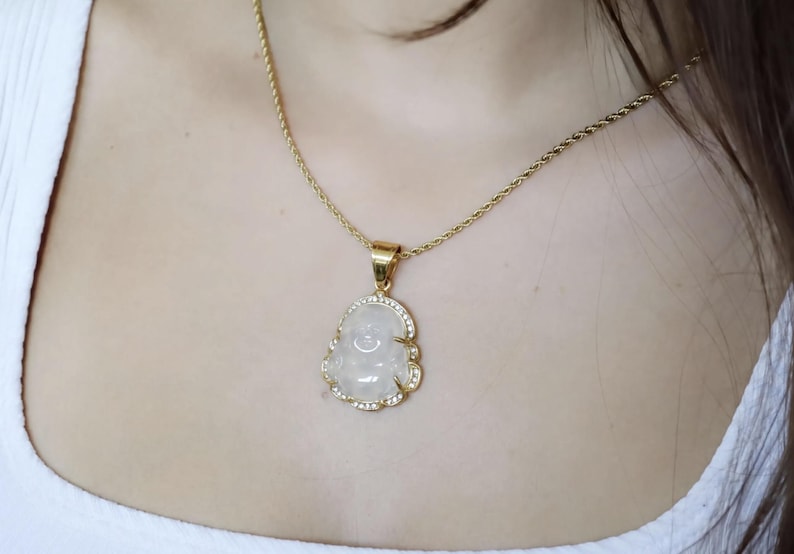 A close-up of a gold necklace with a pendant featuring a white stone or gemstone.