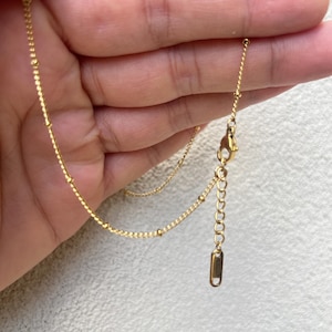 a person holding a gold chain in their hand