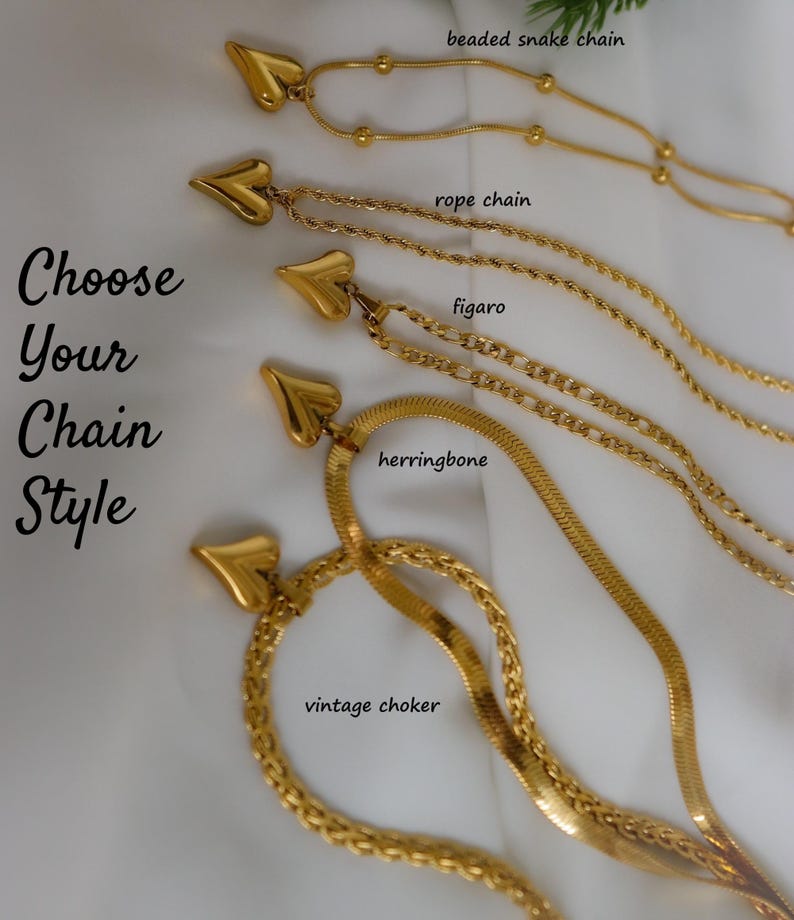 a variety of gold-colored necklaces with heart-shaped pendants, each with different chain styles such as beaded, snake, rope, figuro, herringbone, and vintage choker.
