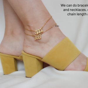 A close-up of a person's feet wearing yellow high-heeled sandals, with a gold-colored ankle bracelet on their ankle.
