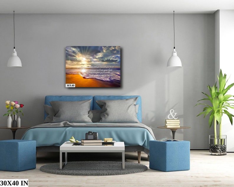 Puede incluir: Una impresi&oacute;n en lienzo con una escena de playa al atardecer. El cielo es una mezcla de naranja, rosa y morado con rayos de luz que brillan a trav&eacute;s de las nubes. Las olas rompen en la orilla y la arena es de color dorado. El texto en la impresi&oacute;n dice: "Donde hay fe, no hay miedo. Yo estoy contigo siempre, hasta el fin del mundo."