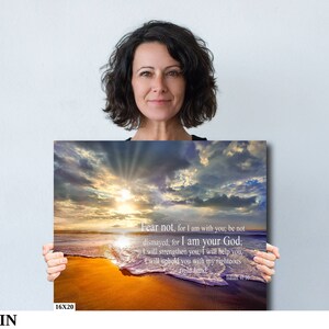 Puede incluir: Una impresi&oacute;n en lienzo con una escena de playa al atardecer. El cielo est&aacute; lleno de nubes y el sol brilla a trav&eacute;s de ellas. Las olas rompen en la orilla y la arena es dorada. La impresi&oacute;n tiene una cita de la Biblia: "No temas, porque yo estoy contigo; no te angusties, porque yo soy tu Dios; te fortalecer&eacute;, te ayudar&eacute;, te sostendr&eacute; con mi diestra victoriosa." - Isa&iacute;as 41:10