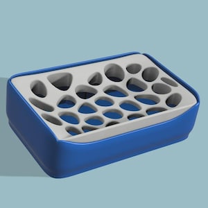 May include: A blue and white container with a grid of holes. The container has a rounded rectangular shape with a blue exterior and a white interior with numerous oval and circular openings.