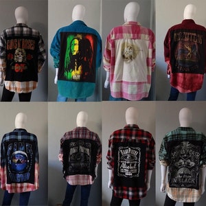 Może przedstawiać: Dziesięć różnych flanelowych koszul z różnymi naszywkami z motywami zespołów i muzyki wszytymi z tyłu. Koszule są w różnych kolorach i wzorach, w tym czerwonym, niebieskim, zielonym i czarnym.