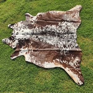 Elevate your space with our Brazilian Cow Hide Rugs – perfect for use as Living Room Rugs, Ottoman Rugs, or striking accent pieces. Made from 100% natural cow skin, each tri-color rug features a beautiful brindle cow hide pattern in rich brown and white tones. These hair-on rugs offer a soft texture and unique charm, making them timeless cow skin rugs for any interior.
