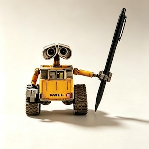 May include: A yellow and grey robot figurine with two large circular eyes and tank treads, holding a long black ballpoint pen in its left mechanical hand. The front of the robot features the text WALL-E in black and red lettering on a yellow panel.