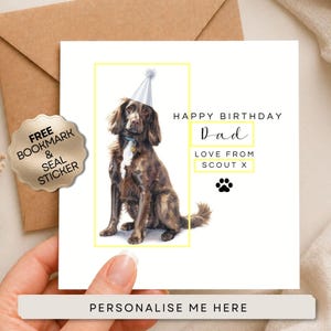 K&ouml;nnte beinhalten: Eine quadratische Geburtstagskarte mit einem braunen Hund, der einen hellblauen Partyhut tr&auml;gt. Der Text lautet HAPPY BIRTHDAY Dad LOVE FROM SCOUT X mit einem schwarzen Pfotenabdruck. Ein goldener Aufkleber zeigt FREE BOOKMARK & SEAL STICKER.