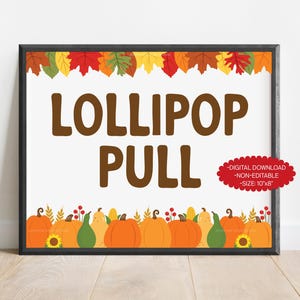 May include: A framed sign with the words "LOLLIPOP PULL" in brown letters. The top of the sign features colorful autumn leaves, and the bottom has illustrations of pumpkins, gourds, and sunflowers. A red oval sticker indicates the size is 10x8 inches.