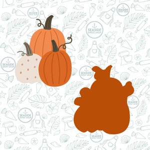 May include: Three pumpkins on a white background with a pattern of seashells, palm leaves, and anchors. The pumpkins are orange and white. The largest pumpkin is in the back and the smallest pumpkin is in the front. The pumpkins are all in focus.