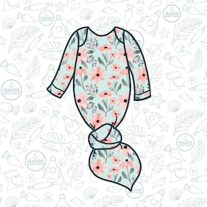 May include: A baby gown with a floral pattern. The gown features a light blue background with pink flowers and green leaves. The gown has long sleeves and a knotted bottom. The background has a repeating pattern of baking-themed illustrations.