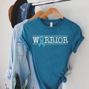a blue shirt with the word warrior on it