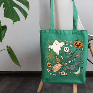 a green trick or treat bag sitting on a chair next to a potted plant