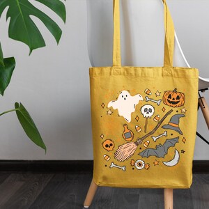 a yellow halloween bag sitting on top of a chair next to a potted plant