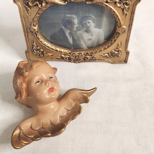 May include: A set of three ceramic mugs with a speckled, matte finish. The mugs are in shades of cream, light gray, and dark gray. Each mug has a simple, minimalist design and a rounded handle. The mugs are likely for coffee or tea.