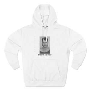 May include: White hoodie with a black and white photo of a man's face on the front. The photo is in a mugshot style with a height chart and the text "#1 GUY IN THE GROUP" underneath.