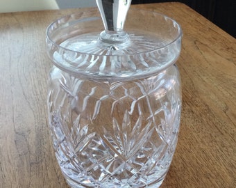 May include: A clear glass jar with a lid, featuring a cut crystal design. The jar has a round body and a wide mouth.