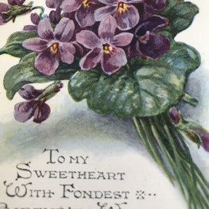 Cartão postal vintage de aniversário com corações e violetas, buquê de flores de 1927