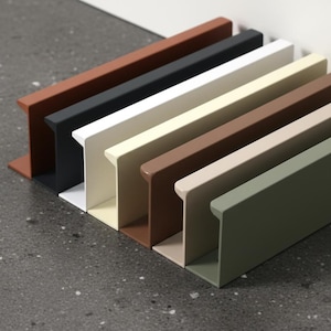 May include: A row of seven rectangular metal shelves in various colors, including rust, black, white, beige, brown, light brown, and olive green. The shelves are arranged in a row on a speckled gray surface.