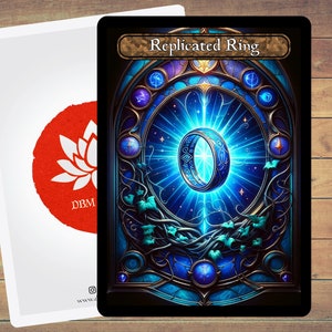 Puede incluir: Un anillo azul y dorado con detalles intrincados, rodeado de una luz azul brillante, sobre un fondo azul oscuro con estrellas y enredaderas. El texto "Replicated Ring" está en la parte superior de la tarjeta.