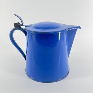 May include: A blue enamel pitcher with a hinged lid. The pitcher has a spout and a handle.